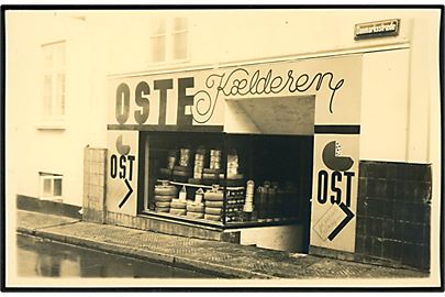 Fredericia. Danmarksstræde med Knud V. Knudsens butik Oste Kælderen. Butikken saboteret i maj 1944. Fotokort H. Henriksen, Frederician u/no.