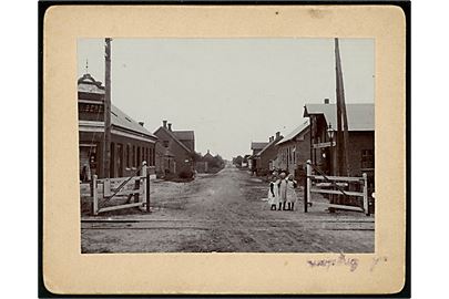 Gørding, Søndergade med jernbaneoverskæring og Gørding Korn- og Foderstofforretning. Fotografi monteret på karton. U/no.