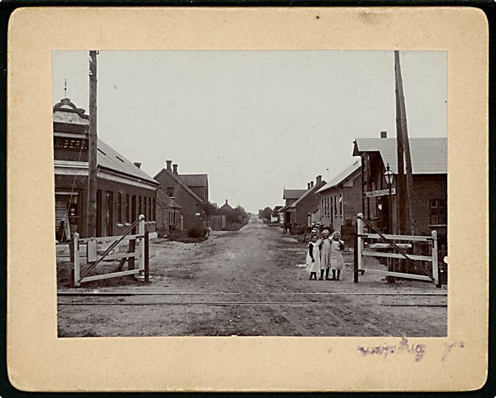 Gørding, Søndergade med jernbaneoverskæring og Gørding Korn- og Foderstofforretning. Fotografi monteret på karton. U/no.