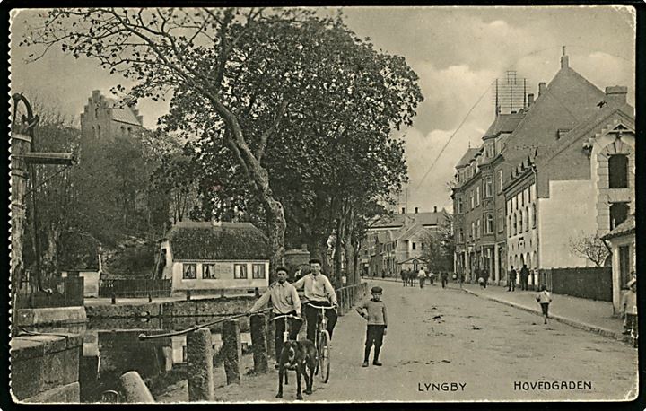 Lyngby, hovedgade med gadekær og kirke i baggrunden. Flensborglagret u/no.