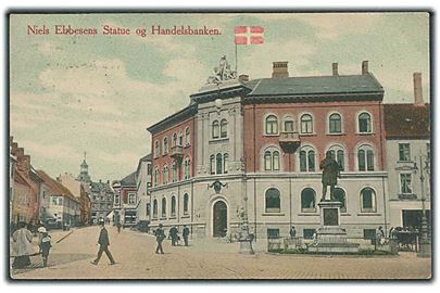 Niels Ebbesens Statue og Handelsbanken i Randers.(Niels Ebbesens er født 1308 og død 2. november 1340. Han var en dansk lavadelsmand, der blev nationalhelt, da han dræbte den kullede greve, grev Gerhard 3. af Holsten i Randers 1. april 1340.)Sommerfeldt Hansens Boghandel, no. ???29.