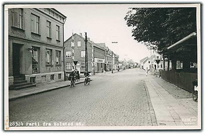 Parti fra Holsted St. med kiosk til venstre. Togskinner / Bom på vejen. Stjernefoto no. 28324. Fotokort. Lille hjørneskade. 