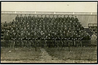 Uniformerede mænd på tribune. Muligvis frivilligt korps. Fotokort fremstillet i Danmark u/no.