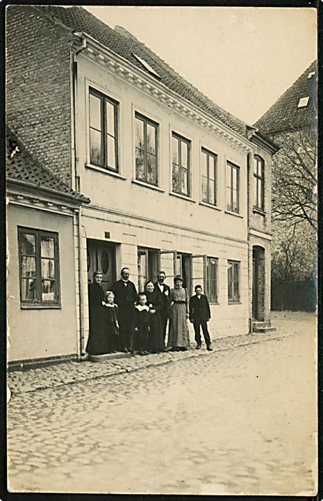 Byhus no. 33, facade med beboere. Ukendt by. Fotokort u/no.